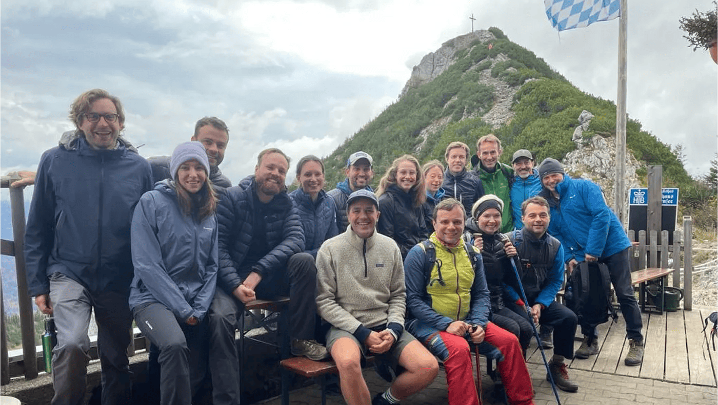 Group photo of founders and investors at the summit of a Bavarian Alps mountain during the Ananda Founder's Resilience workshop in October 2022, featuring mentor Palma Michel leading a resilience workshop.